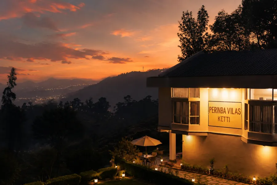 The house lit at dusk above the valley